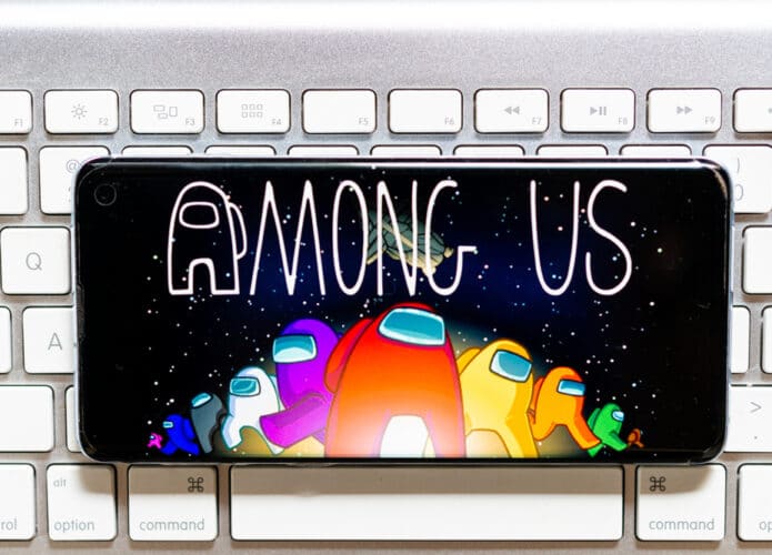 Celular com jogo Among Us na tela em cima de um teclado de computador