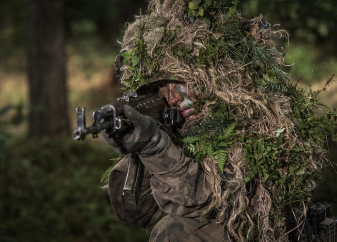 Soldado tentando de camuflar entre folhas