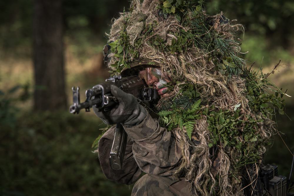 Soldado tentando de camuflar entre folhas