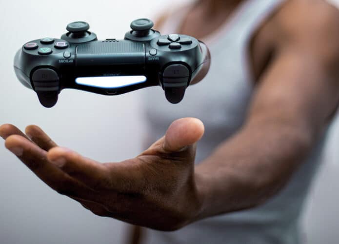 Homem negro parece levitar controle de Playstation 5 com a mão