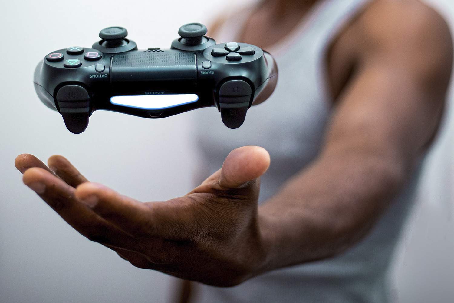 Homem negro parece levitar controle de Playstation 5 com a mão