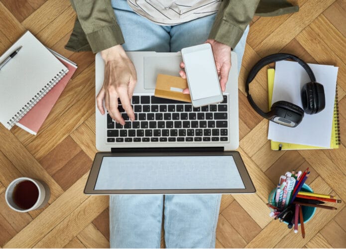 pessoa com computador no colo e acessórios em volta