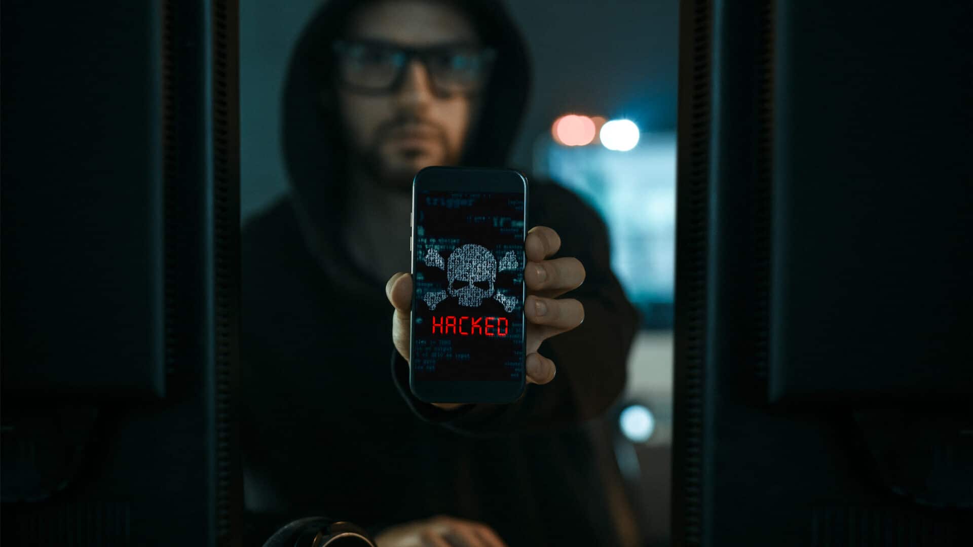 hacker apontando um celular com malware
