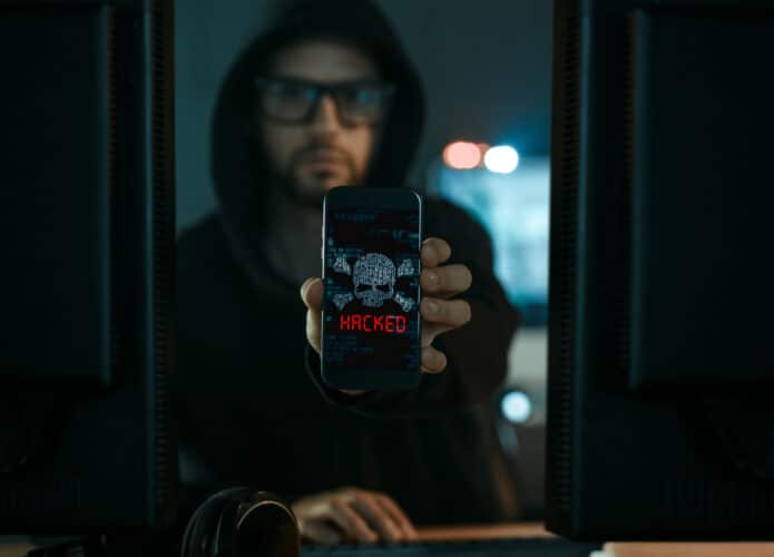 hacker apontando um celular com malware
