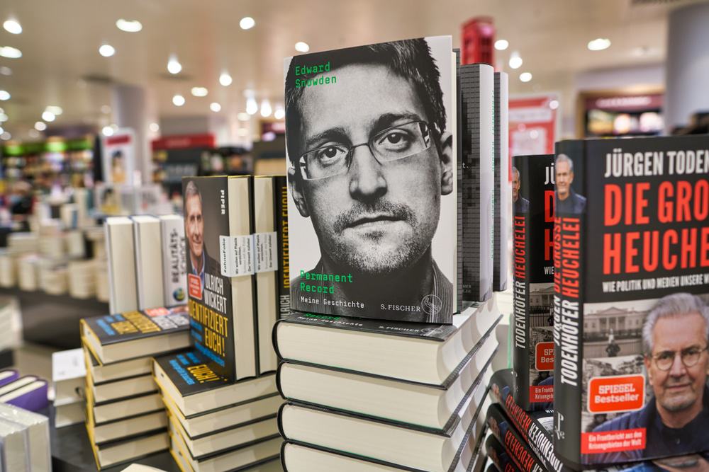 Livros empilhados com foco no livro 'Permanent Record', de Edward Snowden