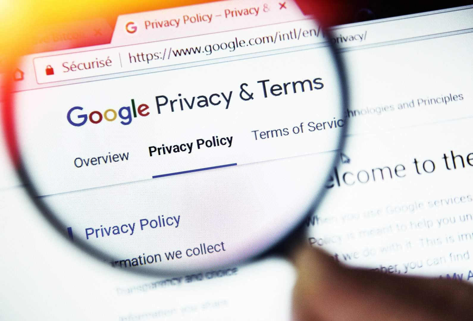 Uma lupa sobre uma tela de computador destaca o logo do Google e a palavra 