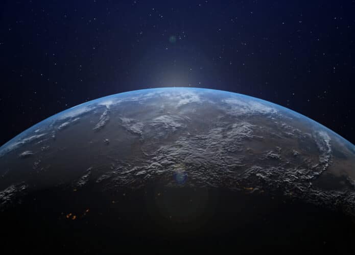 Imagem mostra um pedaço da Terra com o brilho do Sol no horizonte