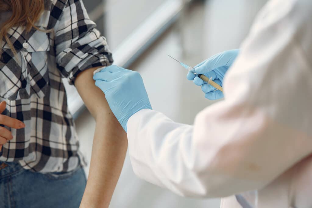 mulher sendo vacinada no braço por um médico