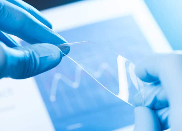 Luvas segurando película transparente