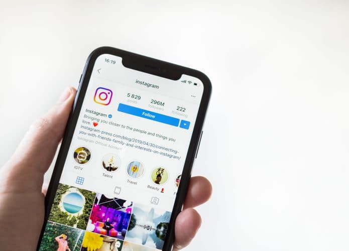 Foto mostra pessoa segurando celular com a rede social Instagram em exibição