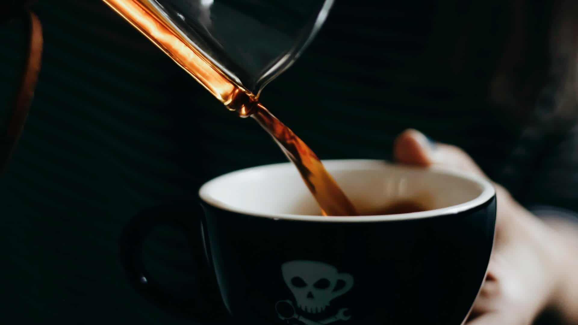 café despejando em xícara preta