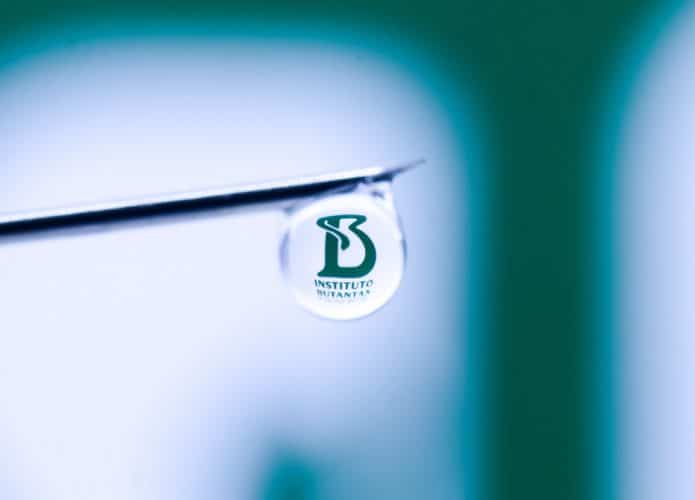 Needle with braziian research institute, Instituto Butantan reflected in drop.