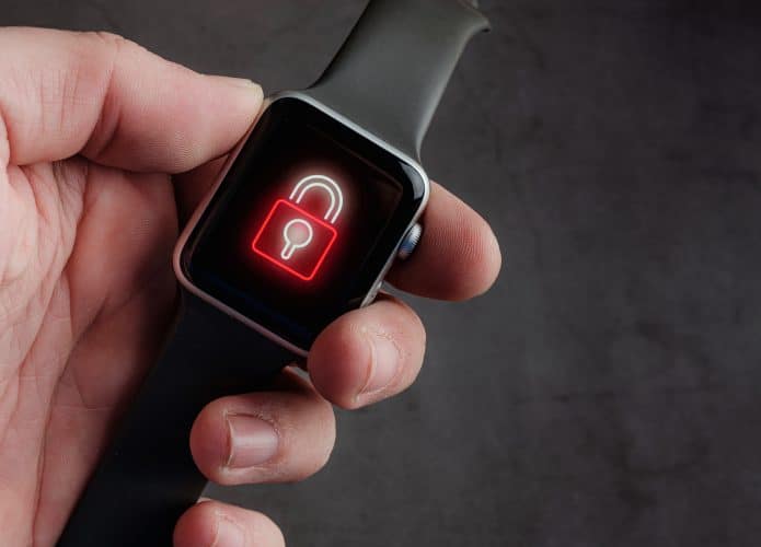 Mão segura um smartwatch que exibe um cadeado no display