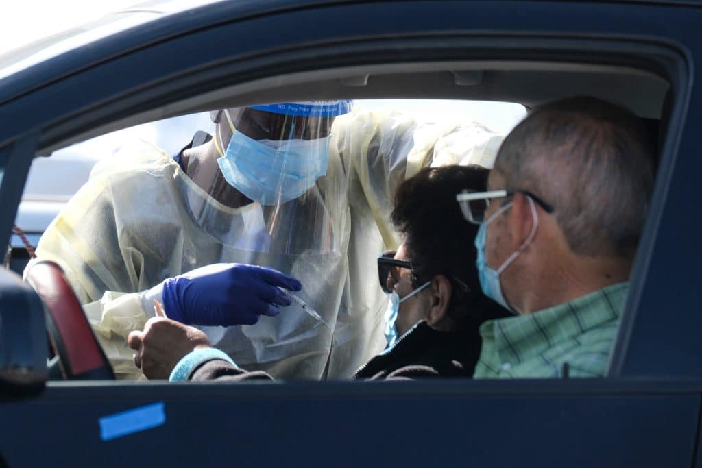 Moradores da Califórnia recebem a vacina contra a Covid-19 em um posto "Drive Thru" nesta terça-feira (19). Imagem: Ringo Chiu / Shutterstock