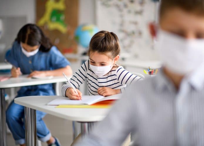 crianças na sala de aula de máscara
