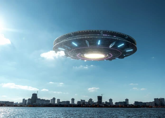 Montagem de uma nave extraterrestre sobre o céu de uma cidade à luz do dia