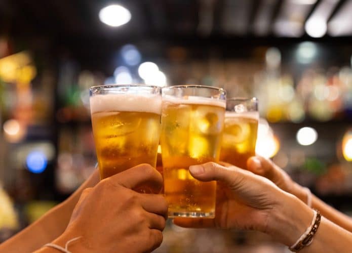 pessoas brindando com copos de cerveja