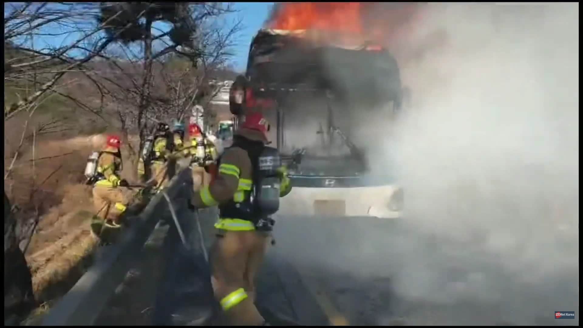 Imagem do ônibus elétrico da Hyundai incendiado, enquanto bombeiros tentam controlar as chamas