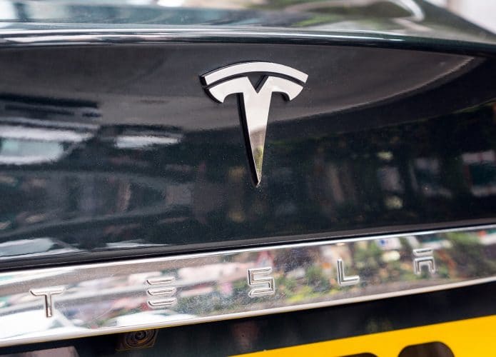 Imagem mostra o logotipo da Tesla na traseira de um carro