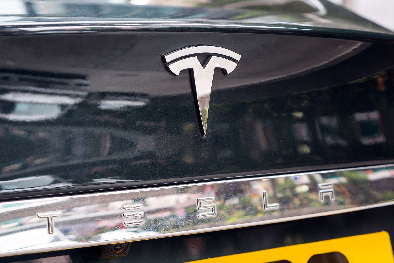 Imagem mostra o logotipo da Tesla na traseira de um carro
