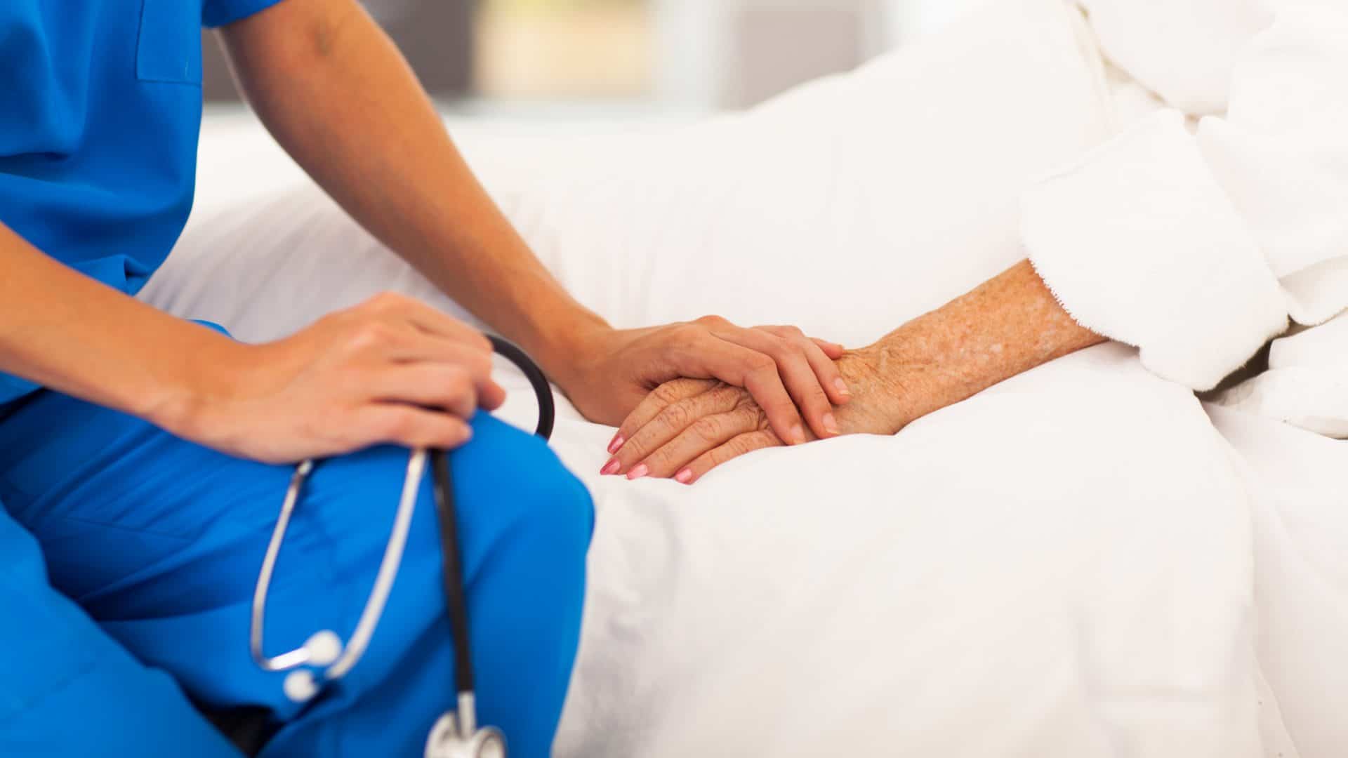 Médico segura a mão de paciente