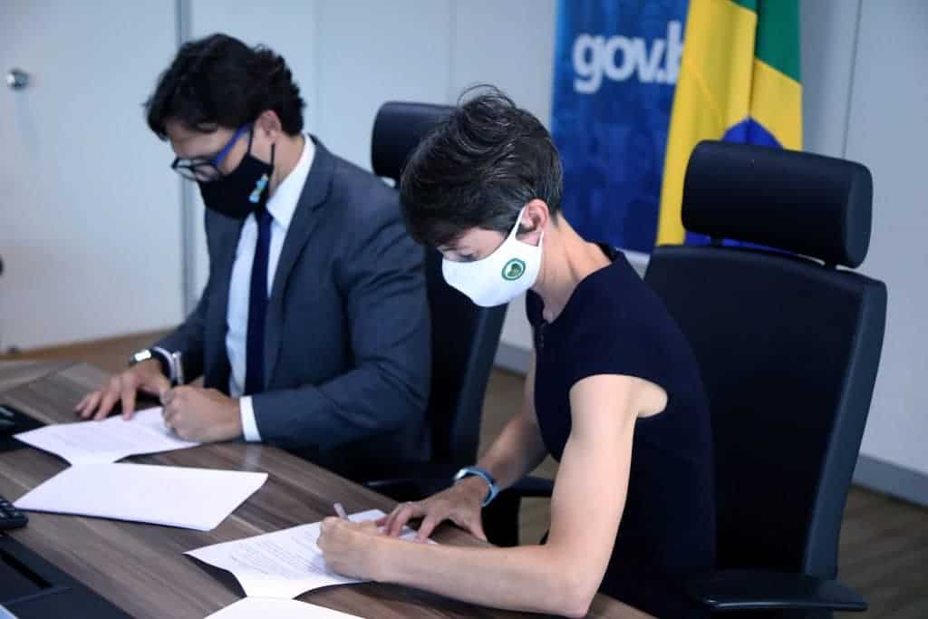Luis Felipe Monteiro, secretário Nacional de Governo Digital e Liz Davidson, Encarregada da Embaixada do Reino Unido, assinando acordo em prol da inovação tecnológica