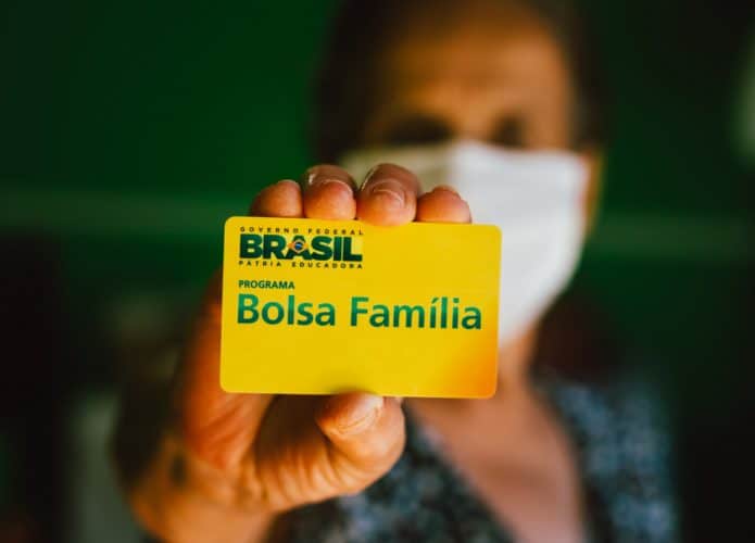Idosa segurando o cartão do Bolsa Família