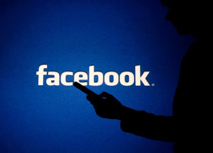 Logo do Facebook com silhueta de uma pessoa no celular