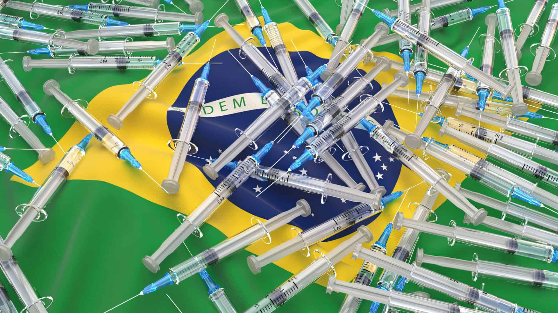 Diversas vacinas contra Covid-19 em cima de uma bandeira do Brasil
