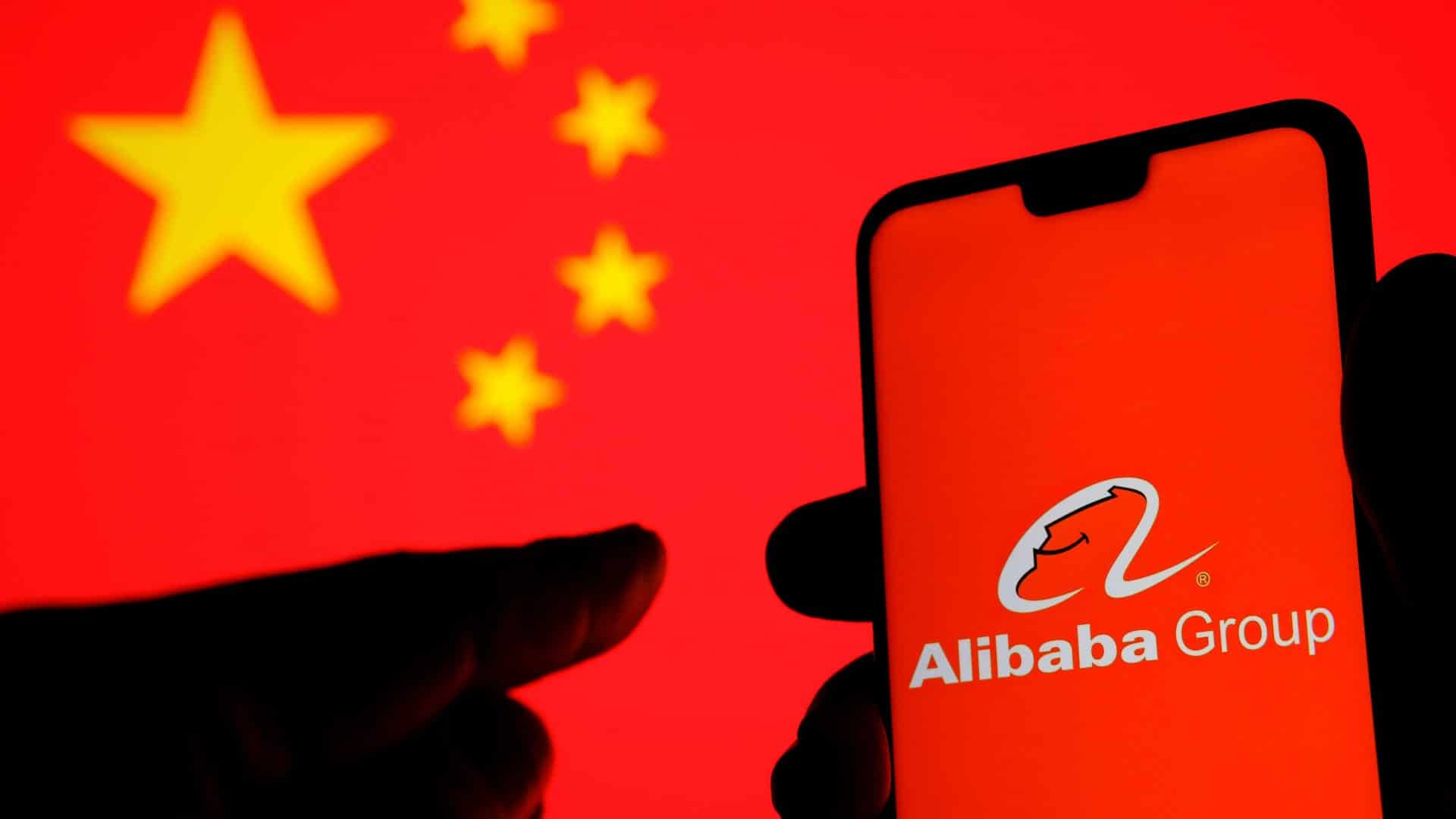 Logo do grupo Alibaba em um smartphone com uma bandeira da China ao fundo