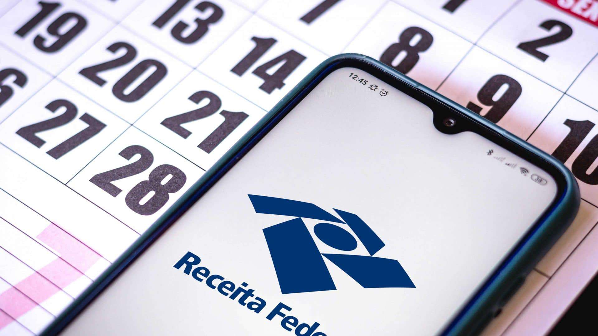 Celular com a logo da Receita Federal em cima de um calendário