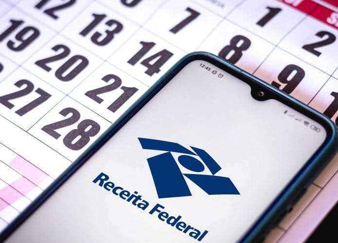 Celular com a logo da Receita Federal em cima de um calendário