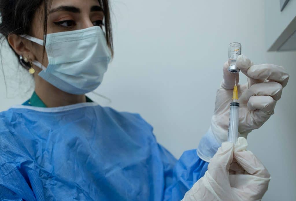 Profissional de saúde da Turquia administrando dose de vacina da CoronaVac Profissional de saúde da Turquia administrando dose de vacina da CoronaVac