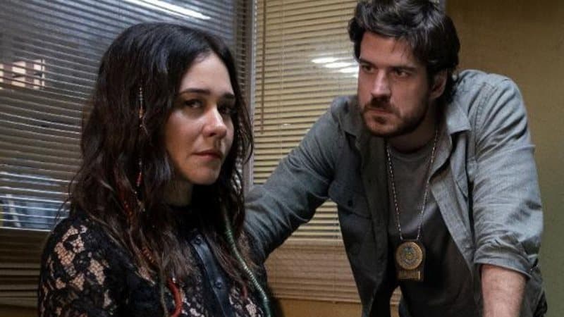 Imagem mostra cena tensa da série "Cidade Invisível", cuja segunda temporada foi confirmada. Na imagem, o ator Marco Pigossi está à direita da atriz Alessandra Negrini, no que parece ser um interrogatório policial.