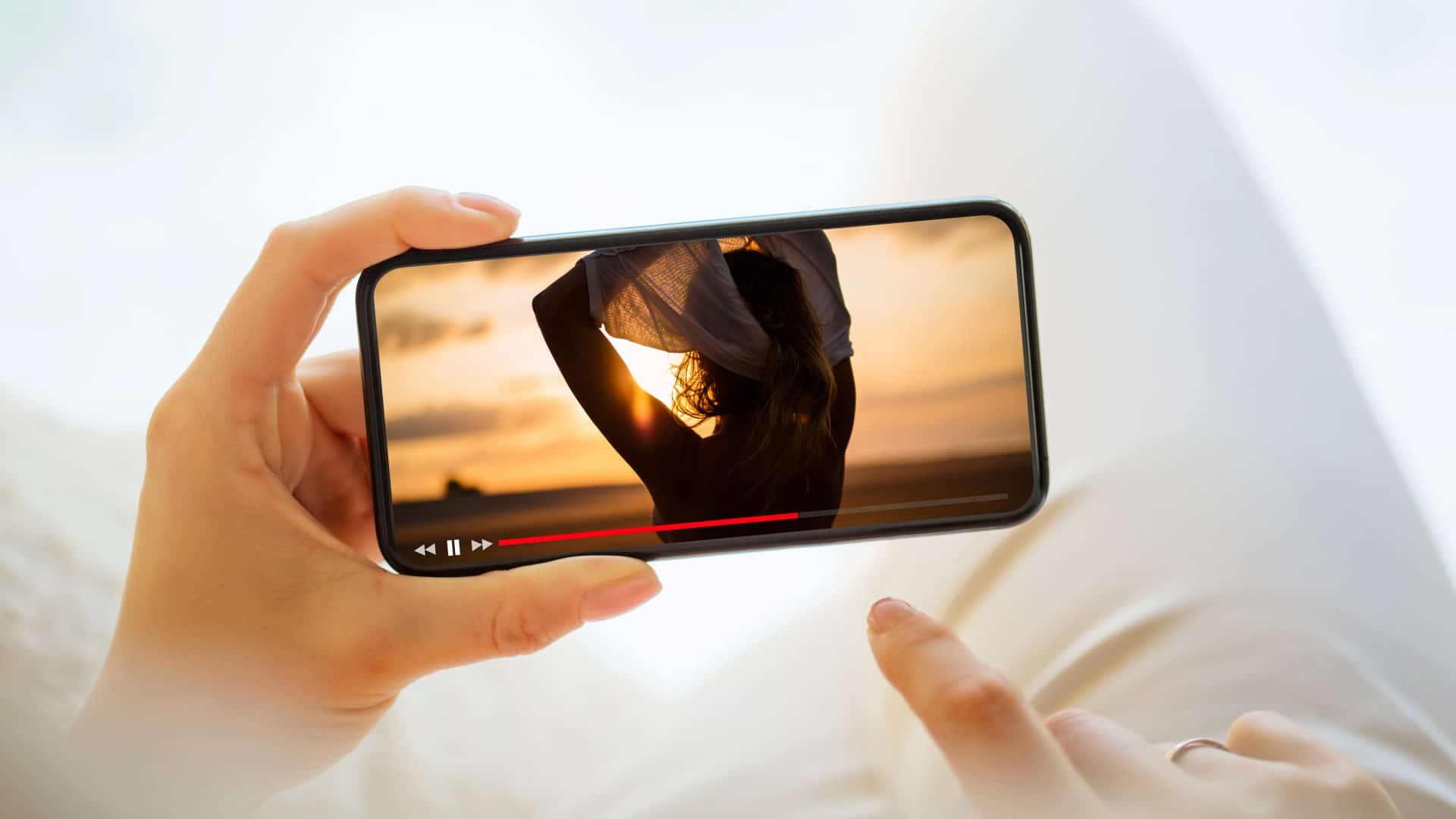mão segurando um celular reproduzindo um filme