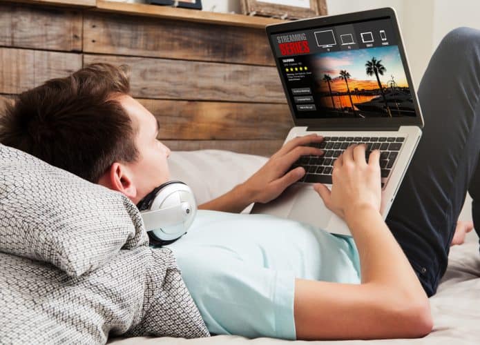 homem assistindo a séries online por um notebook