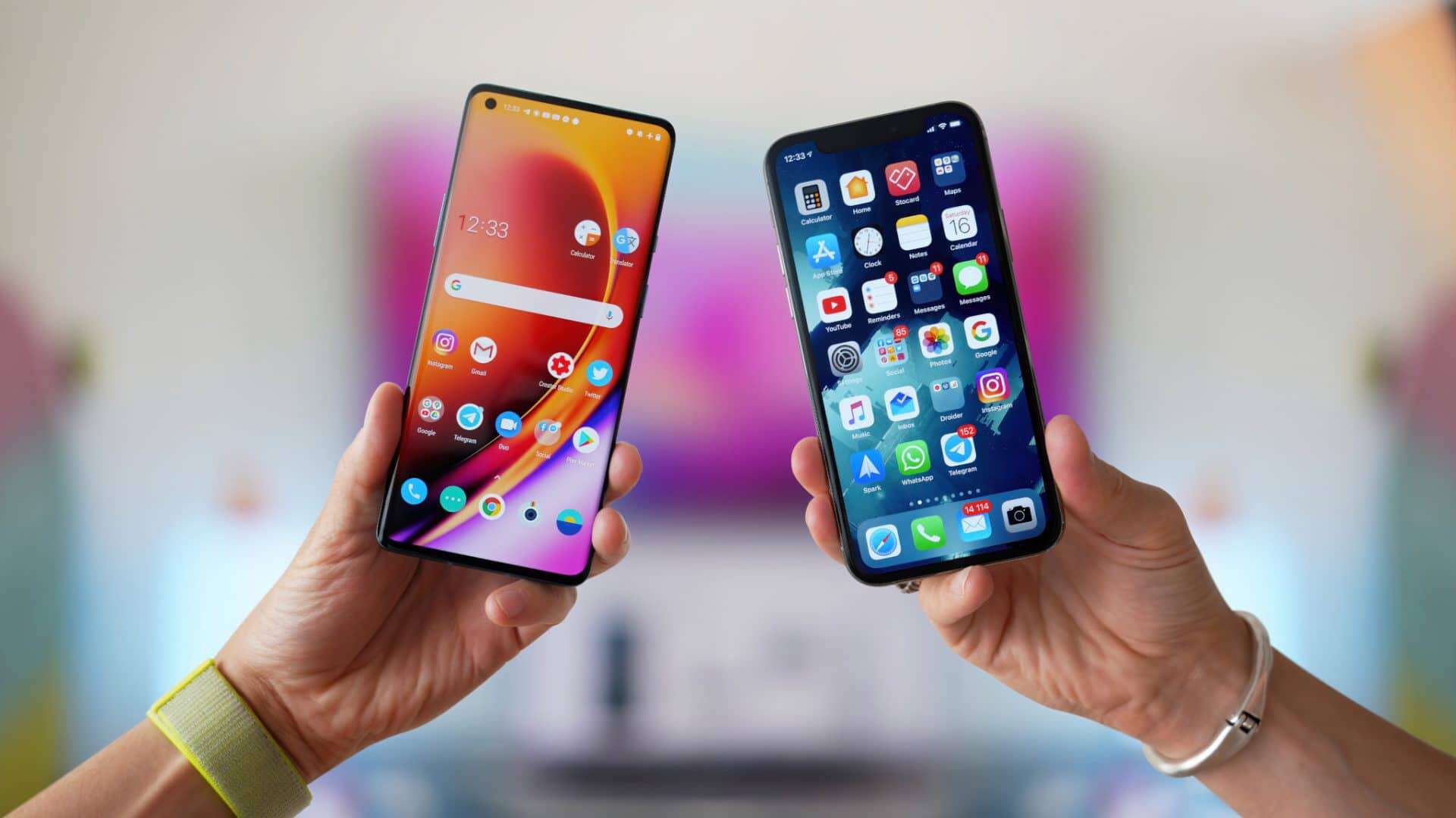 Mãos segurando dois smartphones lado a lado, um iPhone e um Android