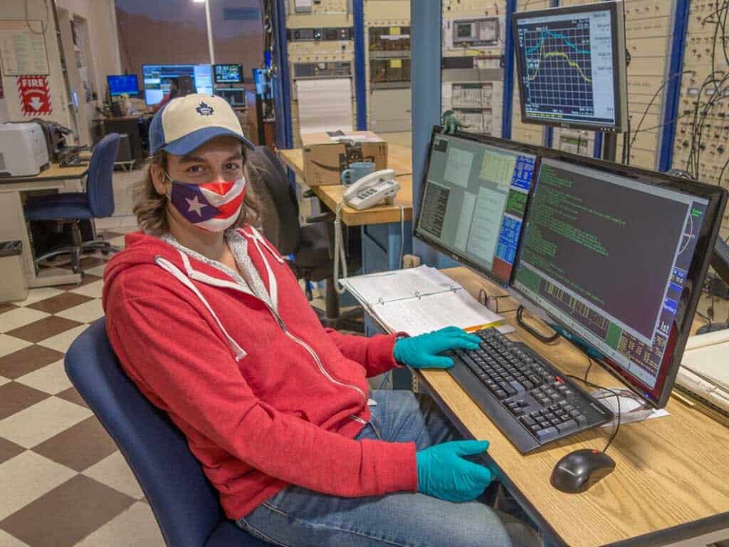 Um homem em frente a vários computadores