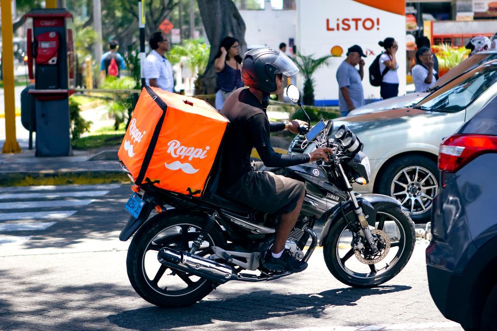 Imagem mostra motoboy com mochila do Rappi, no trânsito.