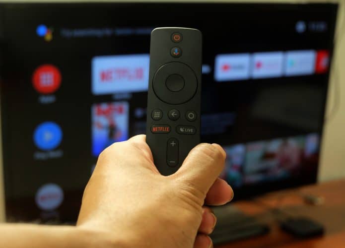 Indivíduo segurando um controle de sua Android TV