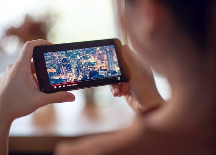 Filmes online com smartphone. Mulher assistindo filme no celular com serviço de player de vídeo