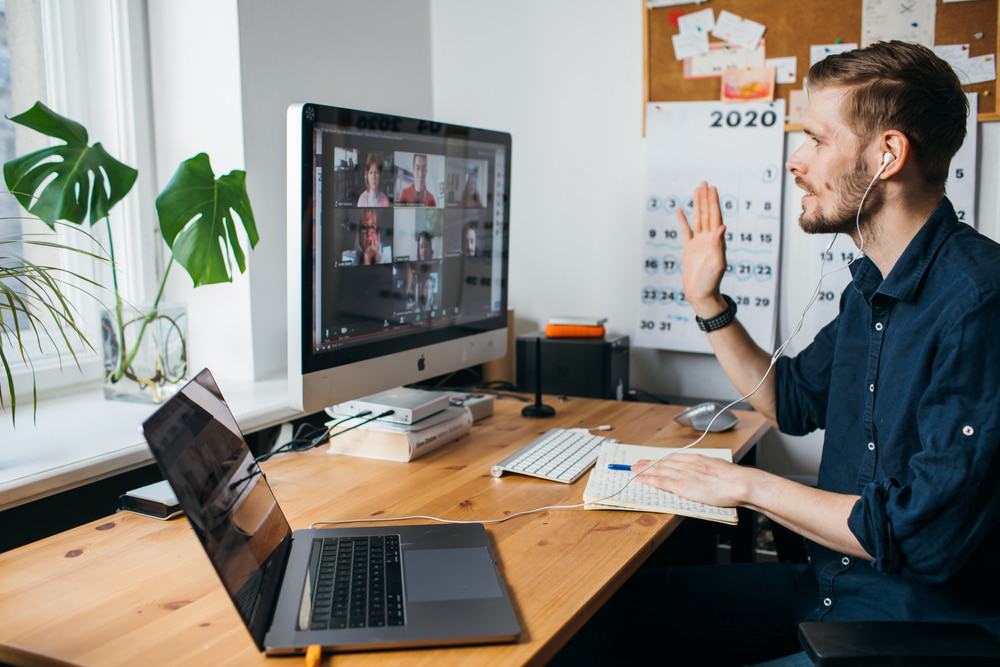 Homem em frente ao computador durante uma reunião do Zoom 