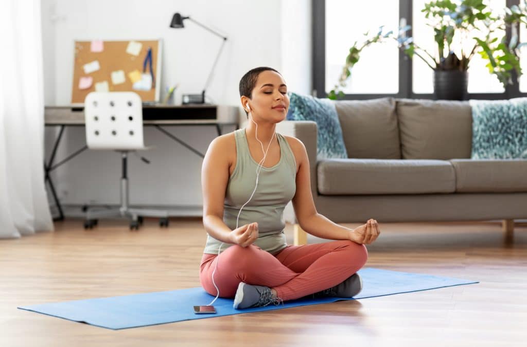 Mulher meditando por meio de um aplicativo de celular