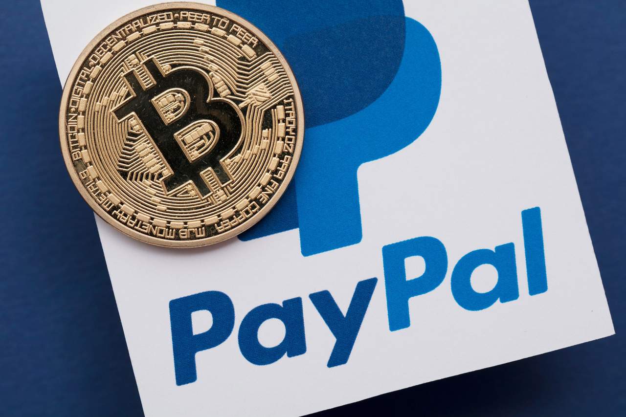 Ilustração de criptomoedas em cima de uma logo do PayPal