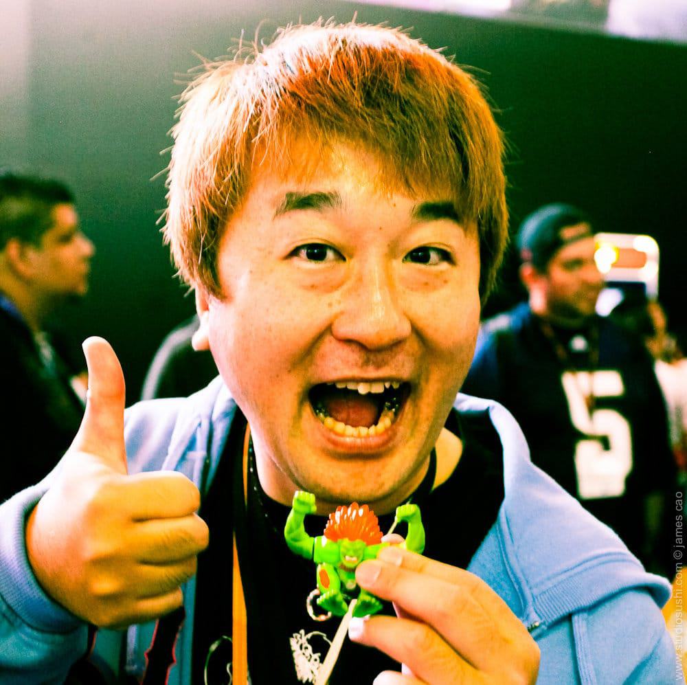 Yoshinori Ono, que deixa a Capcom depois de mais de 20 anos, é mostrado na imagem segurando um boneco do personagem Blanka, que ele carregava consigo para todos os países que visitava