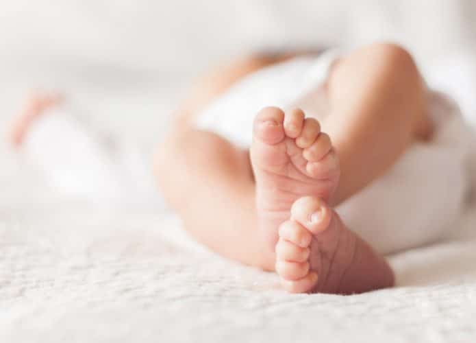 Criança recém-nascida deitada na cama