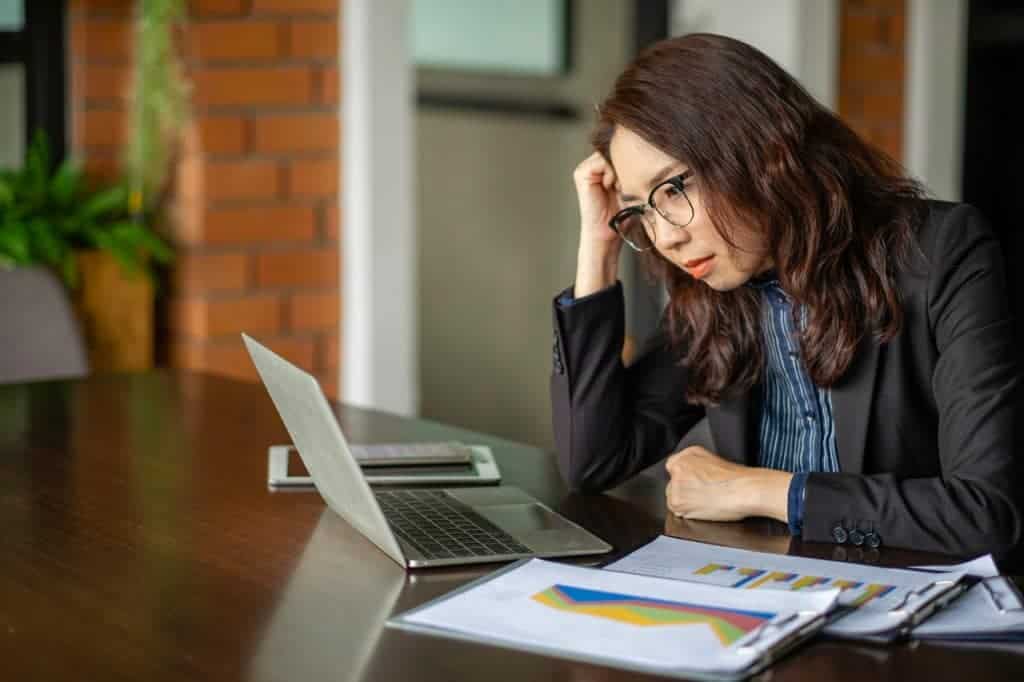 Mulher, em regime home office, com feição de desaprovação