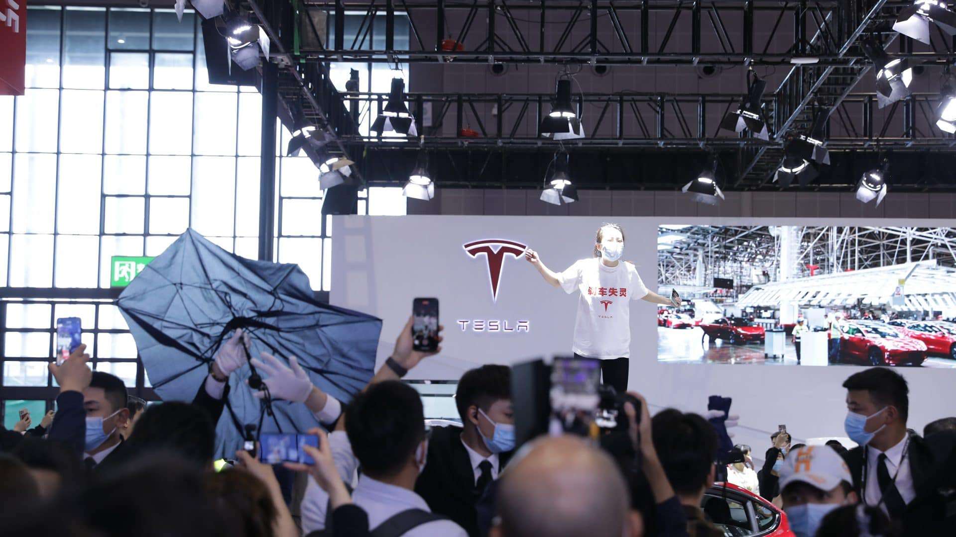Mulher faz protesto contra a Tesla no Salão de Xangai após acidente que quase matou sua família. Imagem: Reprodução/ShangaiEye