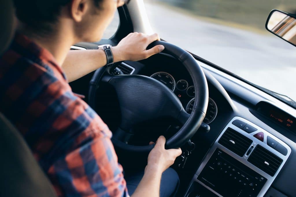 homem sentado dirigindo um carro