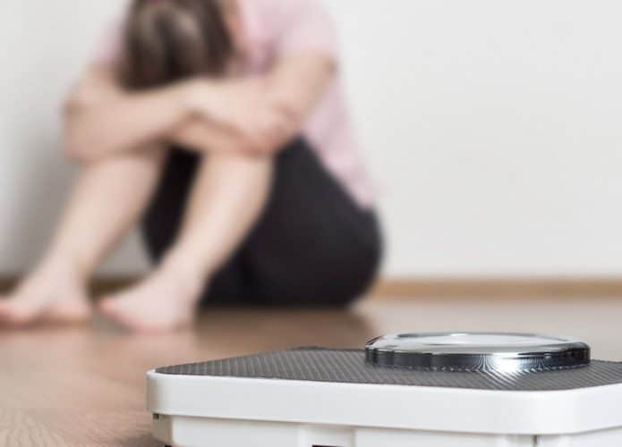 weight-loss-fail-concept-scale-and-depressed-frustrated-and-sad-woman-picture-id813024974-695x500